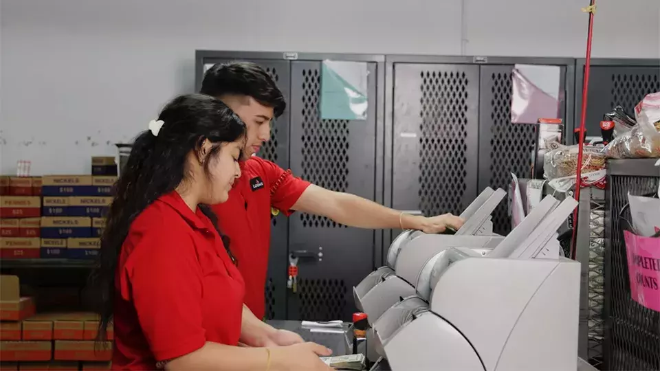 Two Loomis employees using cash handling machine